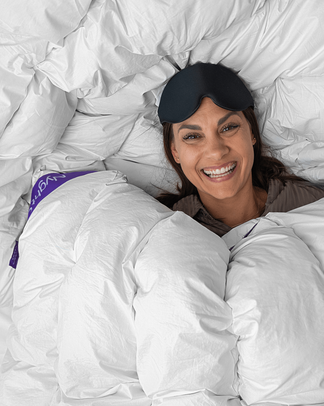 Nyght Hybrid dyne HybridDuvet™. Fyldig tyngdedyne med kombination af vægtfordele og komfort. Billede af en kvinde der ligger med dynen.