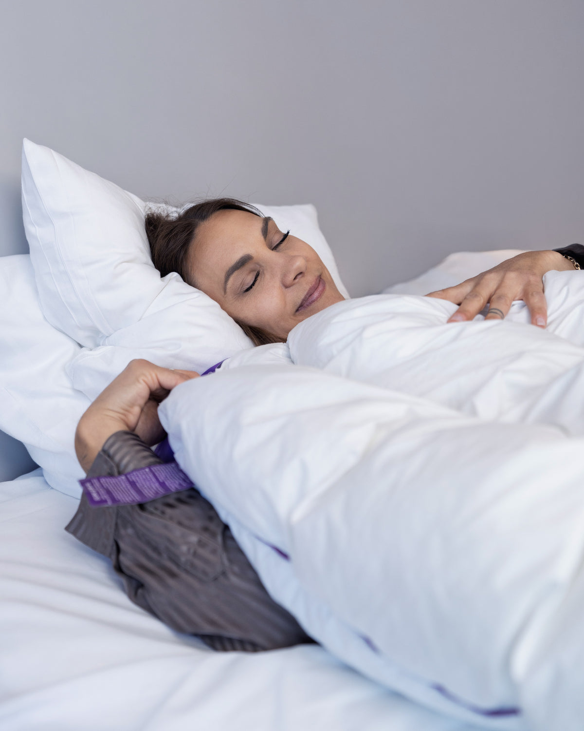 Kvinde sover under Hybridduvet i en almindelig seng